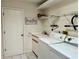 Functional laundry room with washer, dryer, sink, and storage shelves at 2095 Ellery St, Port Charlotte, FL 33952