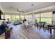 Bright sunroom featuring large windows, wood-look floors and a variety of seating options at 2095 Ellery St, Port Charlotte, FL 33952