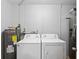 Clean and organized laundry area with modern washer, dryer, and water heater ensuring convenience and efficiency at 2201 Birchcrest Blvd, Port Charlotte, FL 33952