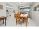 Bright dining area featuring a modern table and chairs, seamlessly connected to the white kitchen and screened-in patio at 2333 Rio De Janeiro Ave, Punta Gorda, FL 33983