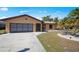 Charming single-story home with a well-manicured lawn, mature palm trees, and a two-car garage at 2333 Rio De Janeiro Ave, Punta Gorda, FL 33983