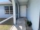 Screened entrance showing the front door with decorative details, complemented by landscaped greenery at 234 Shadow Nw St, Port Charlotte, FL 33952