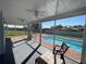 Enjoy the view from the covered patio overlooking a sparkling pool and backyard at 234 Shadow Nw St, Port Charlotte, FL 33952