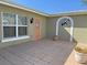 Exterior facade with arched doorway featuring an coral front door and tile flooring in a sunny courtyard at 285 Bal Harbor Blvd, Punta Gorda, FL 33950
