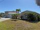 Single-story home with lush landscaping and concrete driveway, with green grass on a sunny day at 285 Bal Harbor Blvd, Punta Gorda, FL 33950