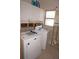 Laundry area featuring a washer, dryer, overhead cabinets, and a window at 285 Bal Harbor Blvd, Punta Gorda, FL 33950
