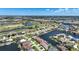 Aerial view of a residential area with homes located along deep water canals and adjacent to a lush green golf course at 341 Segovia Dr, Punta Gorda, FL 33950