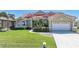 Inviting single-Gathering home showcases a red tile roof, a manicured lawn, palm trees, and a paved driveway at 341 Segovia Dr, Punta Gorda, FL 33950