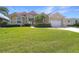 Charming single-story home with well-manicured lawn, tropical landscaping, and a striking red tile roof at 341 Segovia Dr, Punta Gorda, FL 33950