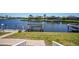 Scenic waterfront view with a boat lift, lush lawn, and houses across the water at 341 Segovia Dr, Punta Gorda, FL 33950