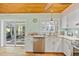Bright kitchen featuring white cabinetry, stainless appliances, and sliding glass doors to the sunroom at 4114 Yucatan Cir, Port Charlotte, FL 33948
