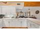 Kitchen with white cabinets, stone countertops, and view into the adjacent living room at 4114 Yucatan Cir, Port Charlotte, FL 33948