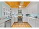 Bright kitchen with white cabinetry, stainless steel appliances, and a unique wooden ceiling fan at 4114 Yucatan Cir, Port Charlotte, FL 33948