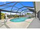 Large screened-in pool area with a hot tub and waterfront canal view at 4114 Yucatan Cir, Port Charlotte, FL 33948