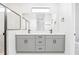 A bathroom features a double sink vanity with a white countertop and marble-tiled shower at 5110 Burri Ct, North Port, FL 34288