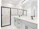 This bathroom includes a double sink vanity and a marble-tiled shower with a glass enclosure at 5110 Burri Ct, North Port, FL 34288