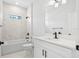Bathroom featuring modern vanity, framed mirror, marble wall tile, and black accents at 5110 Burri Ct, North Port, FL 34288