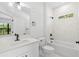 Stylish bathroom with white marble-like tile, modern fixtures, and plenty of natural light at 5110 Burri Ct, North Port, FL 34288