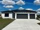 Beautiful single-story home featuring a three-car garage and a well-manicured front lawn at 5110 Burri Ct, North Port, FL 34288