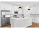 Bright kitchen featuring a large island, stainless steel appliances, and white cabinets at 5110 Burri Ct, North Port, FL 34288