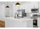 An open kitchen boasts an island with a sink, stainless steel appliances, and white cabinetry at 5110 Burri Ct, North Port, FL 34288