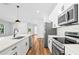 Stylish kitchen with stainless steel appliances, center island, white cabinets, and wood-look flooring at 5110 Burri Ct, North Port, FL 34288