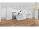 Open concept living and kitchen area featuring modern lighting, appliances, and wood flooring at 5110 Burri Ct, North Port, FL 34288