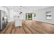 Open concept living and kitchen area featuring modern lighting, appliances, and wood flooring at 5110 Burri Ct, North Port, FL 34288