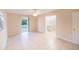 An empty bedroom with light tile flooring, neutral walls, and access to an ensuite bathroom and outdoor patio at 536 Lakehurst Nw Ave, Port Charlotte, FL 33952