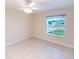 Bedroom features neutral walls, tile floor, and a large window with view of the neighborhood at 536 Lakehurst Nw Ave, Port Charlotte, FL 33952