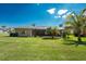 Lush backyard with a screen enclosed lanai and tropical landscaping provides an inviting outdoor living space at 619 Boundary Blvd, Rotonda West, FL 33947