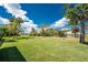 Expansive backyard featuring lush green grass, mature trees, and a serene outdoor space perfect for relaxation at 619 Boundary Blvd, Rotonda West, FL 33947