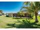 A beautiful yard with a screen enclosed lanai and tropical landscaping provides an inviting outdoor living space at 619 Boundary Blvd, Rotonda West, FL 33947