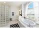 Luxurious bathroom features a soaking tub, glass block shower, and large window at 619 Boundary Blvd, Rotonda West, FL 33947
