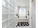 Bright bathroom featuring a glass block wall, soaking tub under an arched window, and a patterned black and white rug at 619 Boundary Blvd, Rotonda West, FL 33947