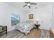 Bright bedroom with wood-look flooring, ceiling fan, and sunlit window at 619 Boundary Blvd, Rotonda West, FL 33947