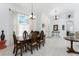 Bright dining room with large windows, neutral paint, pendant lighting, and classic wood dining set at 619 Boundary Blvd, Rotonda West, FL 33947