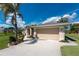 Charming home with a well-manicured lawn, mature trees, and a welcoming entrance at 619 Boundary Blvd, Rotonda West, FL 33947