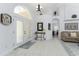 Bright foyer with neutral tile floors, white paint, a decorative mirror, and arched doorway accents at 619 Boundary Blvd, Rotonda West, FL 33947