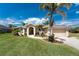 Charming single-story home with beautiful landscaping and a well-manicured lawn with tropical palm tree at 619 Boundary Blvd, Rotonda West, FL 33947
