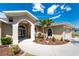 Attractive home with arched entryway, beautiful landscaping, and a well-maintained front lawn at 619 Boundary Blvd, Rotonda West, FL 33947