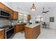 Bright kitchen featuring stainless steel appliances, granite counters, a center island, and wood cabinets at 619 Boundary Blvd, Rotonda West, FL 33947