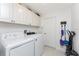 Functional laundry room with white cabinetry, washer, dryer and storage at 619 Boundary Blvd, Rotonda West, FL 33947