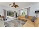 Living room featuring neutral paint, a ceiling fan, backyard access, and decorative furnishings at 619 Boundary Blvd, Rotonda West, FL 33947
