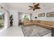 Inviting living room with stylish ceiling fan, plush leather sofa, and large patterned rug at 619 Boundary Blvd, Rotonda West, FL 33947