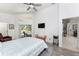 Bright main bedroom with vaulted ceiling, lanai access, ceiling fan, and doorway to main bathroom at 619 Boundary Blvd, Rotonda West, FL 33947