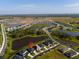 Aerial view of a modern home in a Primary-planned community with a lake and lush landscaping at 6315 164Th E Ave, Parrish, FL 34219
