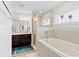 Well-lit bathroom featuring a tub with tile surround, glass enclosed shower and granite vanity at 6315 164Th E Ave, Parrish, FL 34219