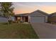 Charming single-story home with well-maintained lawn and a two-car garage during sunset at 6315 164Th E Ave, Parrish, FL 34219