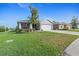Single-story home with landscaped lawn, two-car garage, and a sidewalk in a residential neighborhood at 6315 164Th E Ave, Parrish, FL 34219